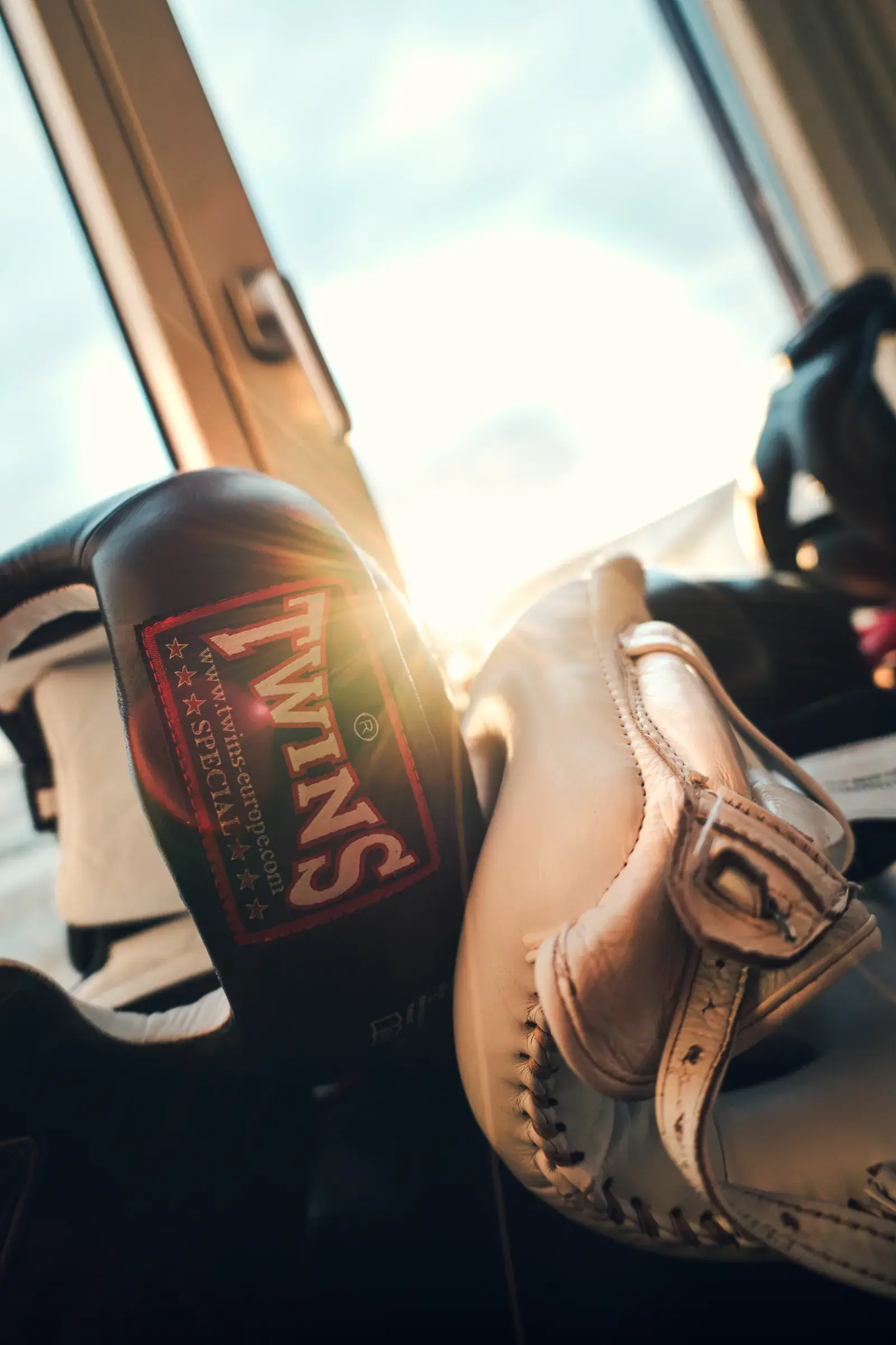 Schwarze und helle Boxausrüstung der Marke Twins am Fenster des America Boxing Gym, im Gegenlicht der Sonne.