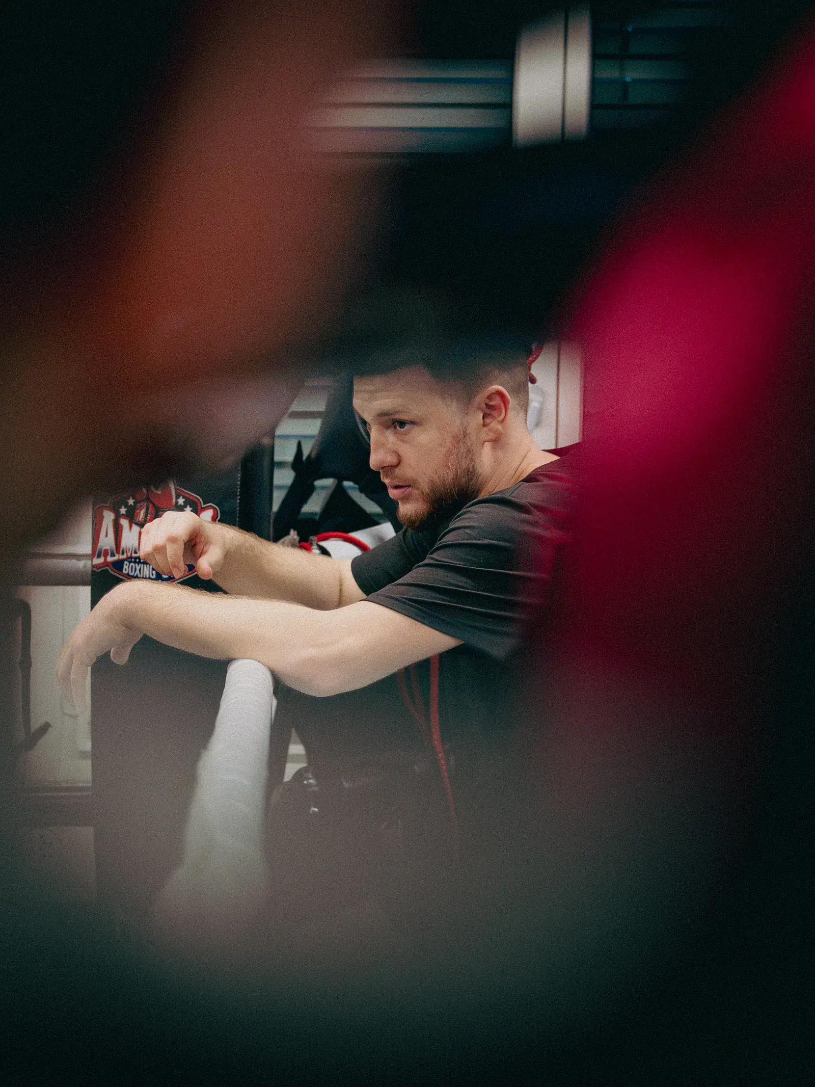 Coach lehnt am Ringseil und beobachtet konzentriert das Geschehen im Ring.